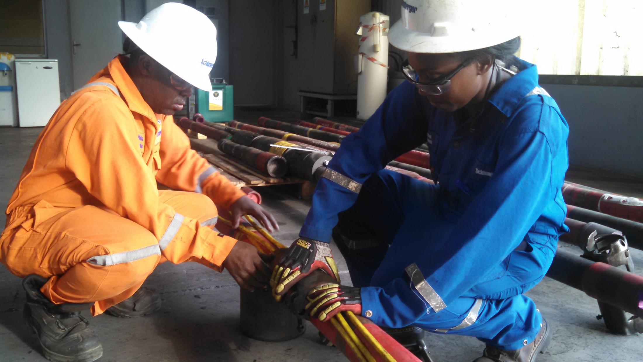 man and woman in hard hats working on a pipe