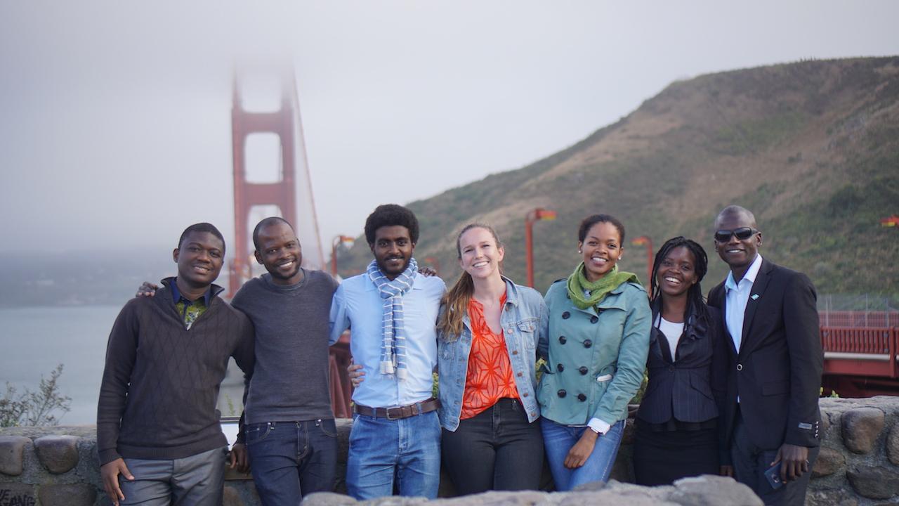 group of young people standing in front of the golden gate bridge 