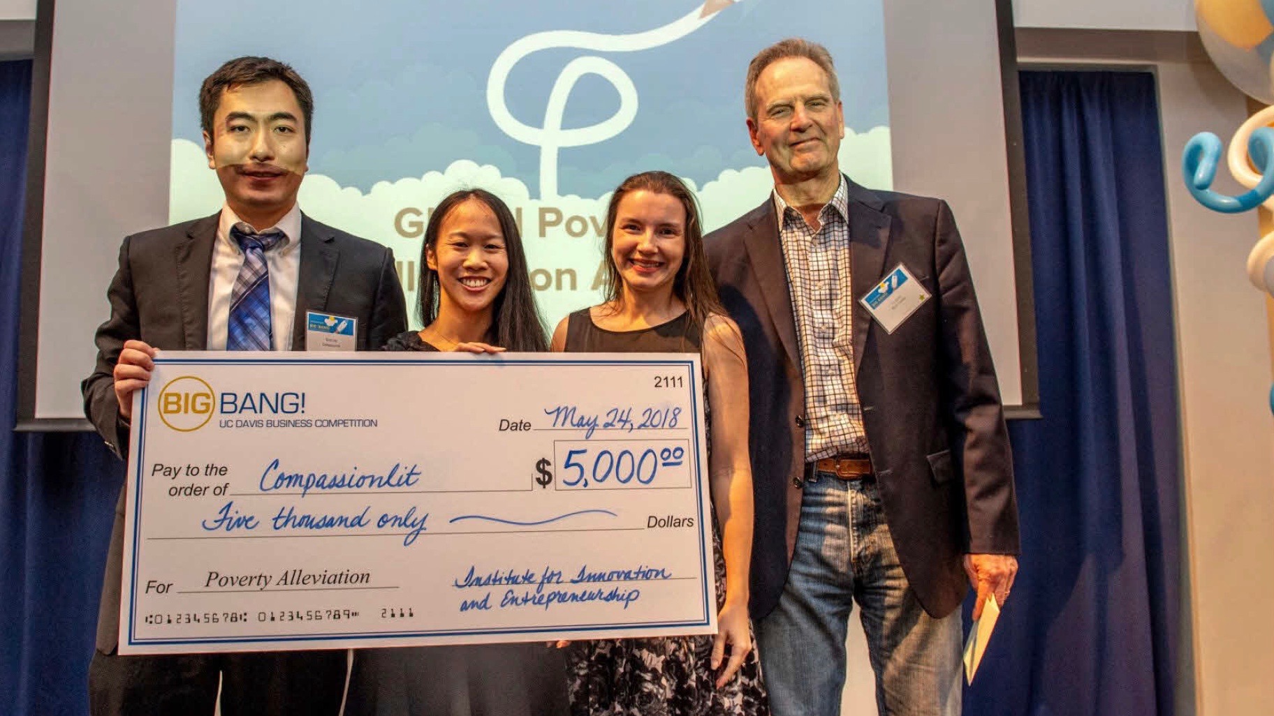 He and Ma holding prize check with Blum Center staff