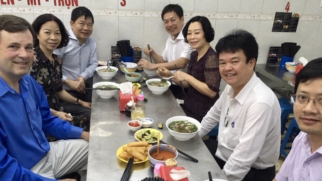 Hinton enjoying phở gà, a special Vietnamese chicken soup breakfast, with key members of the research team in Hanoi