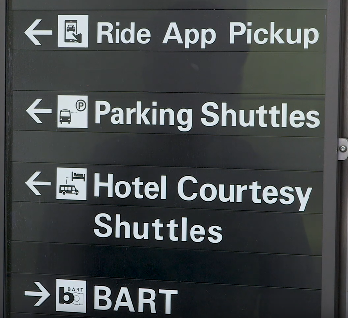Airport sign with arrows pointing to where the different types of transit are located.
