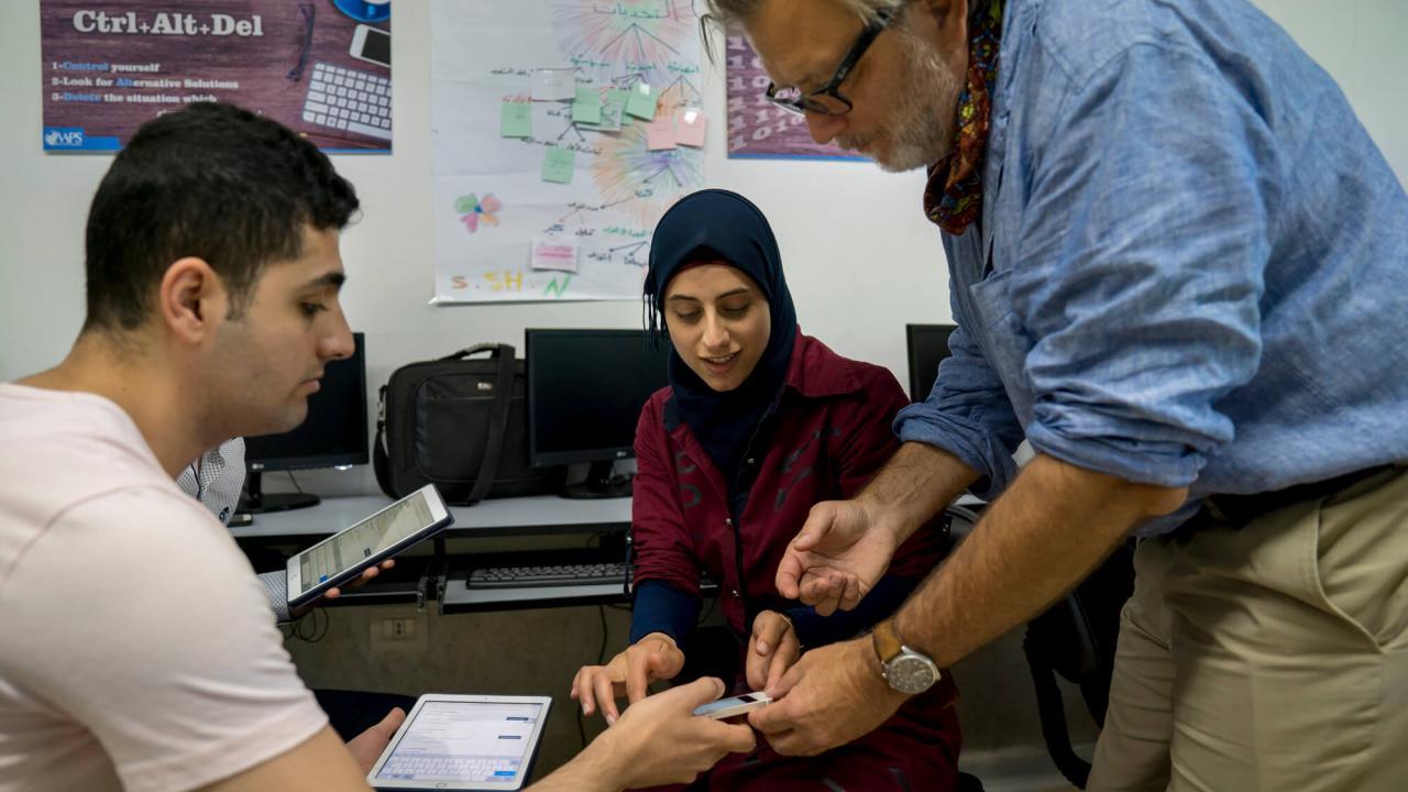 Keith David Watenpaugh (right), professor and director of Human Rights Studies, helping Ali Almarzouki register for the Article 26 Backpack in the Bekaa Valley. Watenpaugh's Article 26 Backpack project is addressing UN Sustainable Development Goal 4 by helping refugees and other vulnerable young people reclaim their right to education with technology. (Joe Proudman/UC Davis)