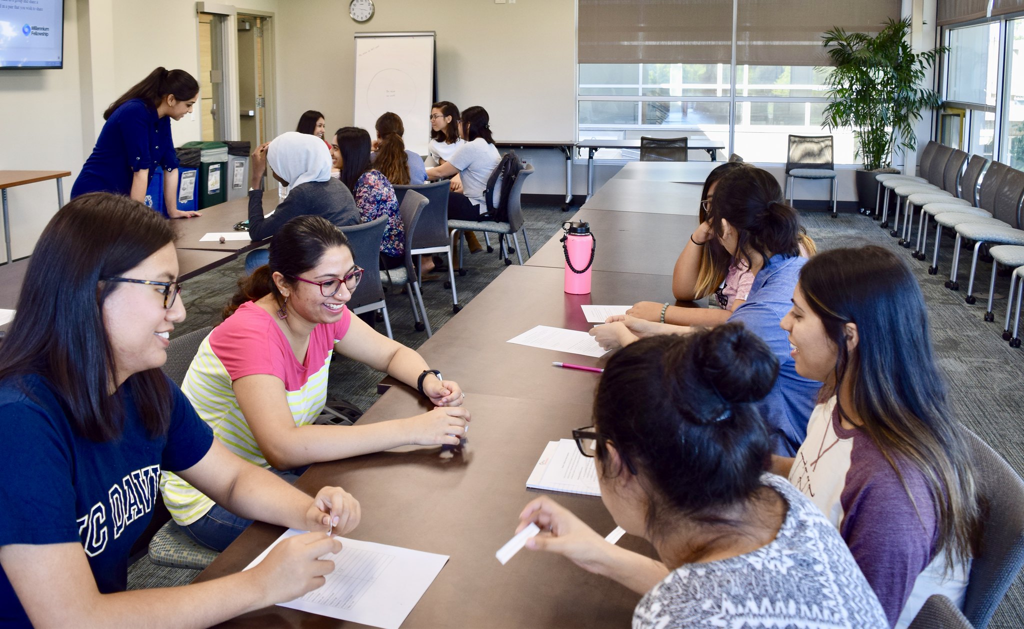 Groups of students working on projects together in conference room setting