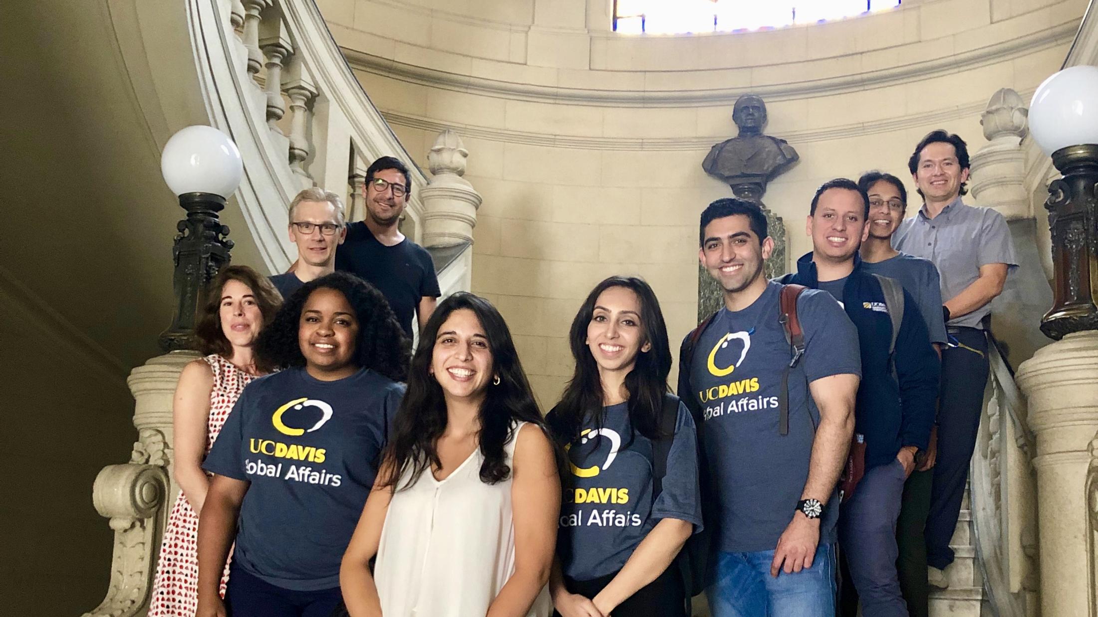 UC Davis MBA students and a faculty member stand on steps in Chile while working on their capstone project