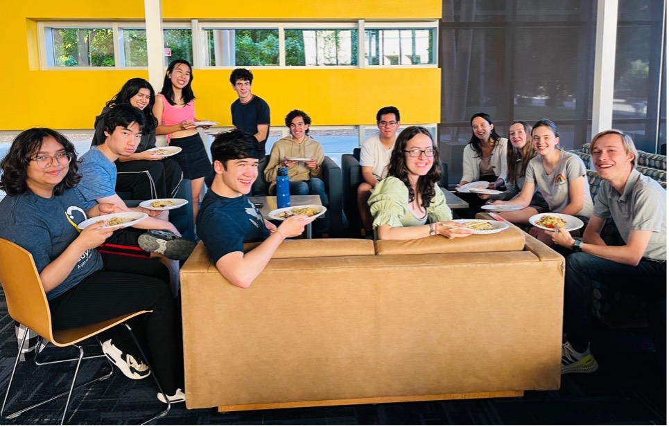 Group of students sitting around a table and smiling.