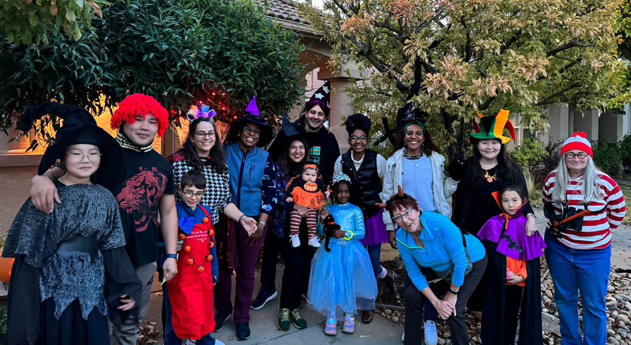 Humphrey Fellows, their children and hosts pose for a photo dressing in Halloween costumes.