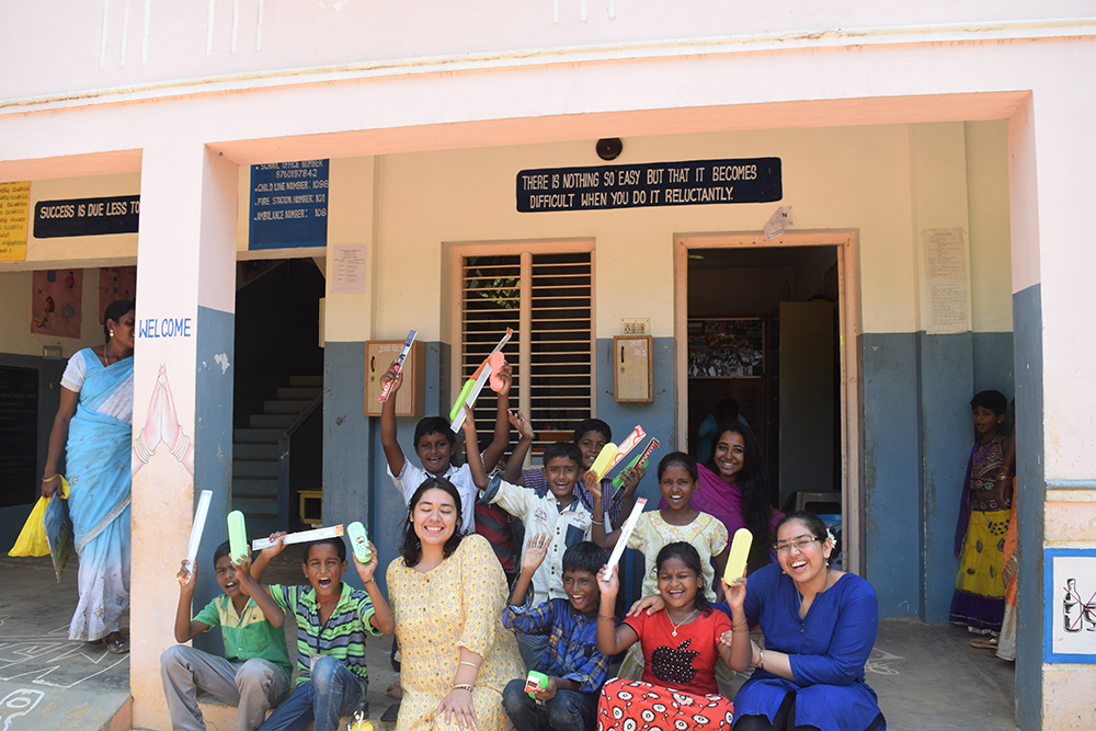 UC Davis student Radhika Marwaha working on Project Rishi surrounded by kids in India