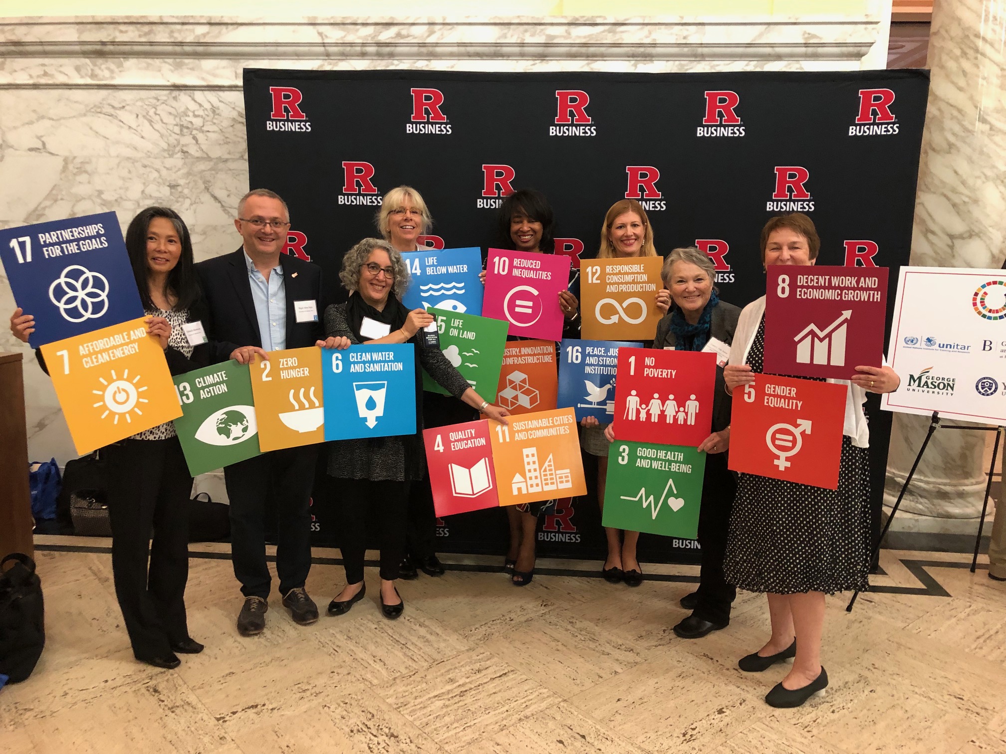 Photo of UC Davis faculty holding of signs with the UN SDGs on them