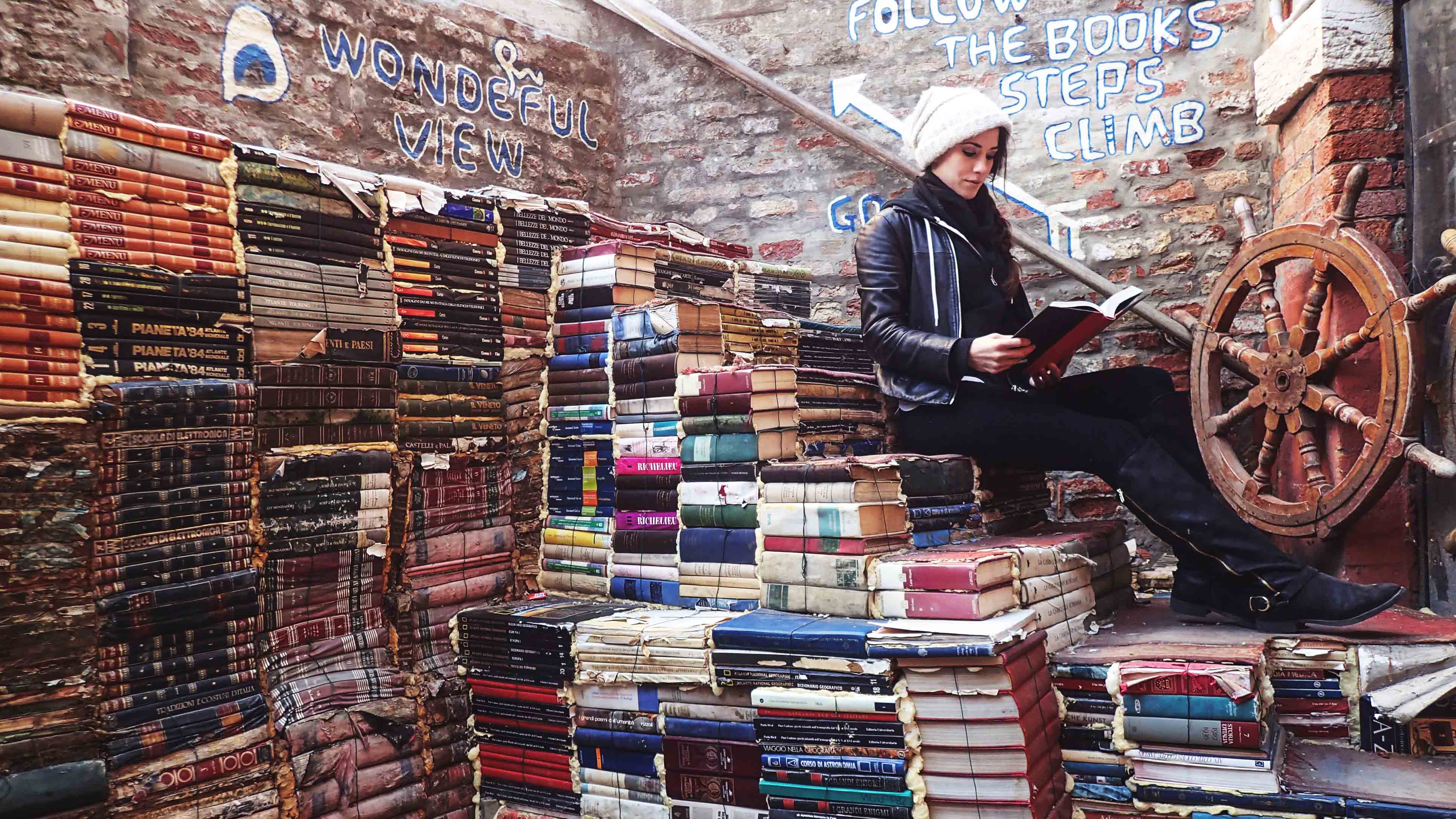 Image of a girl sitting on a staircase made of books