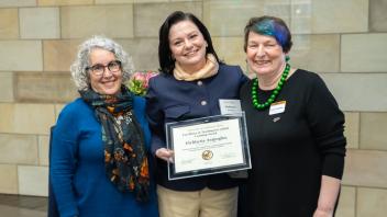  Nancy Erbstein, Eleftheria Arapoglu and Joanna Regulska smile at the camera while holding an award