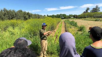a person leads a tour of open agricultural fields