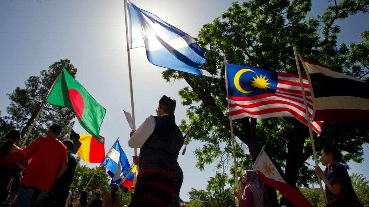 Picnic Day Parade participants carry flags from around the world.