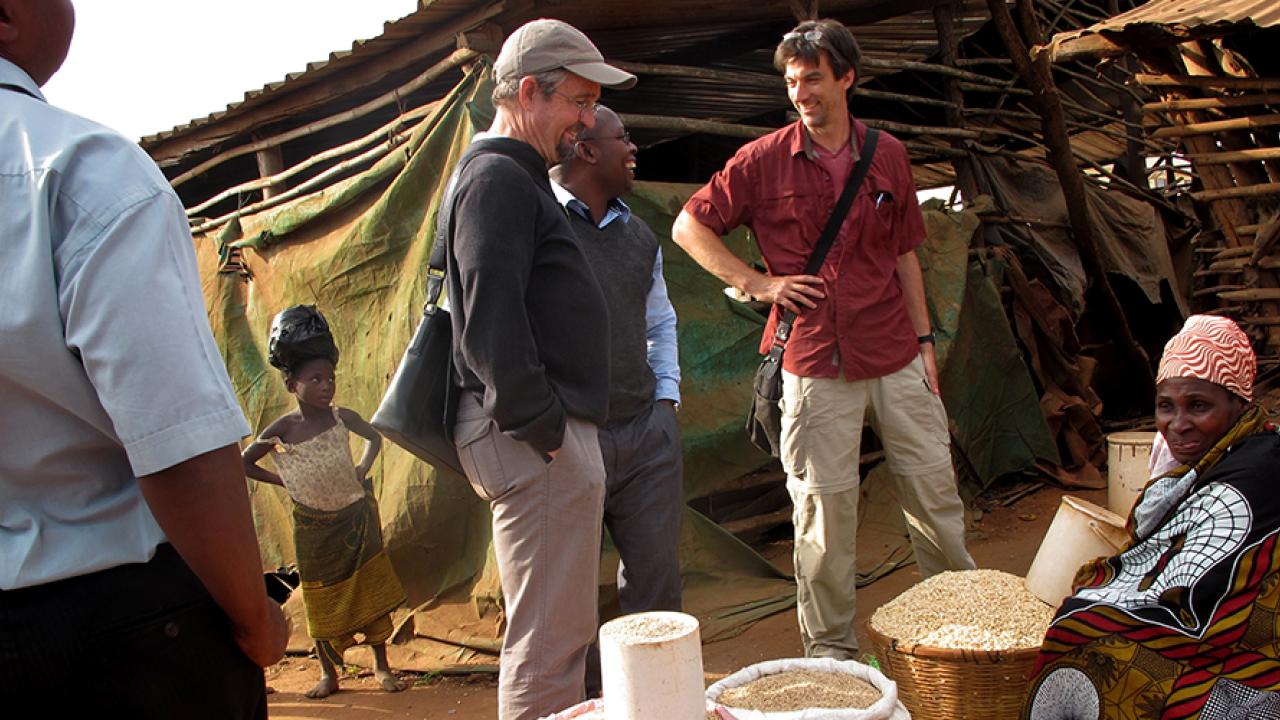 Principal investigators Michael Carter (third from left) and Stephen Boucher (second from right) visit a local market in Mozambique with their local research partners. (Jonathan Malacarne/AMA Innovation Lab) Michael Carter and Stephen Boucher visit market
