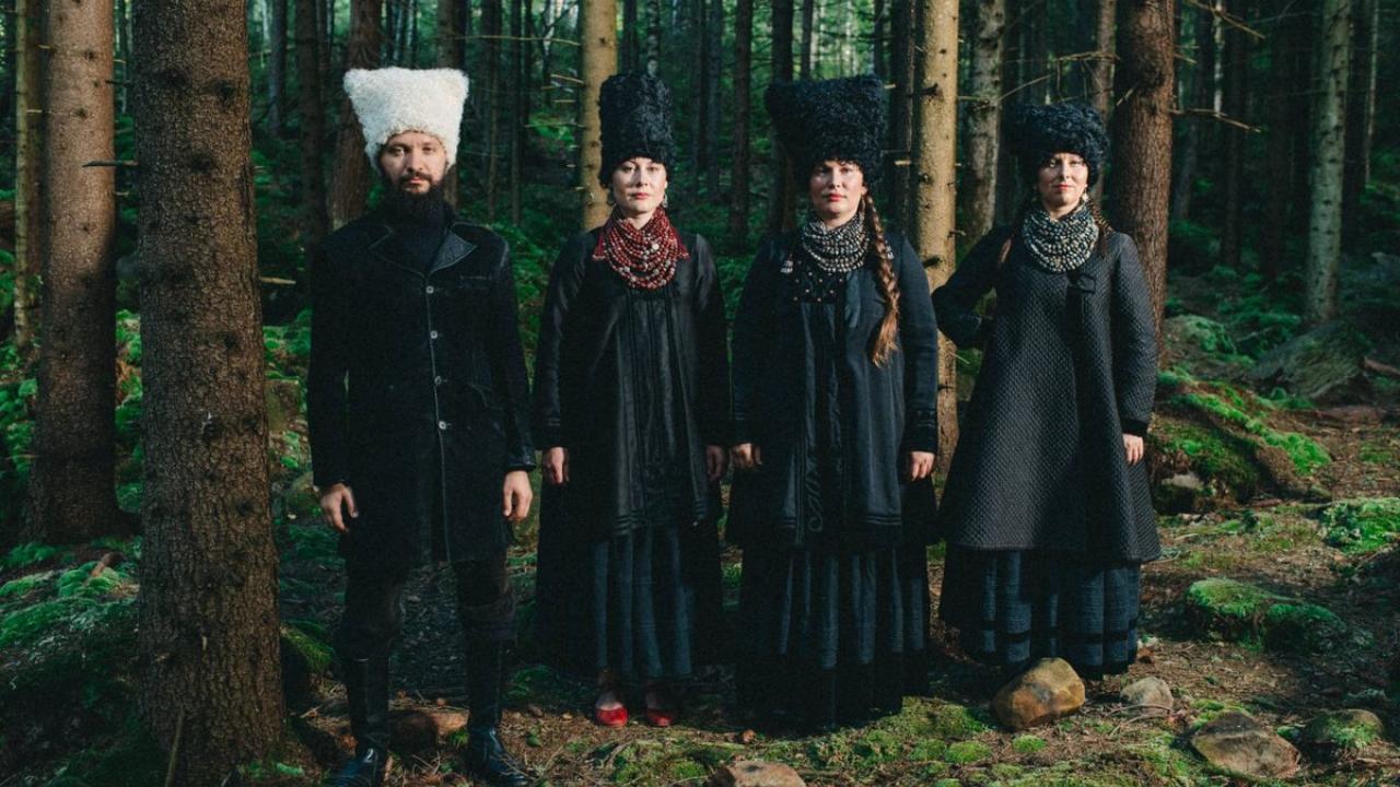 4 people stand together in the forest.