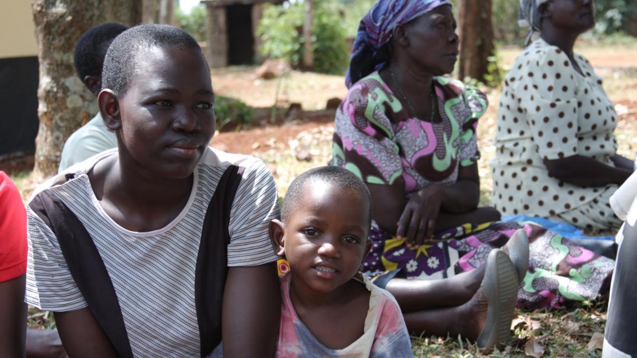 Photo of women and children in Sub-Saharan Africa sitting on the ground