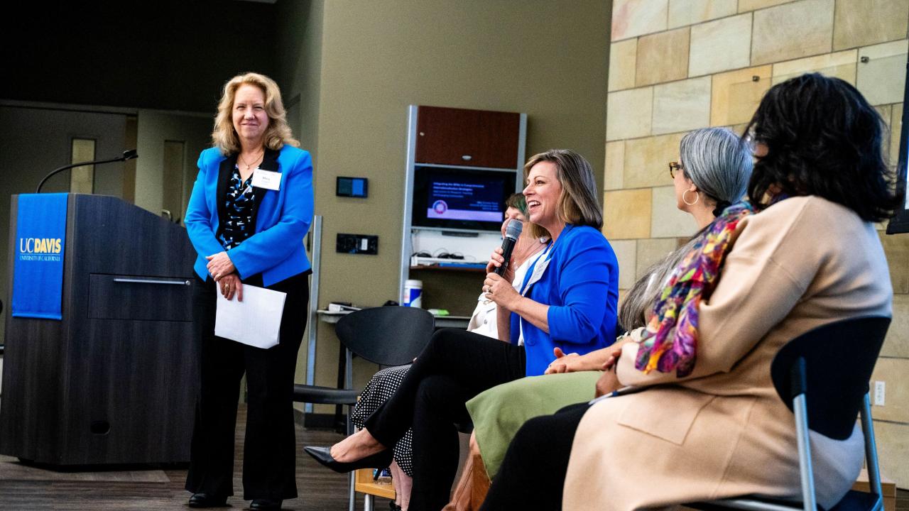 A panel of female presenters listening to a panel member