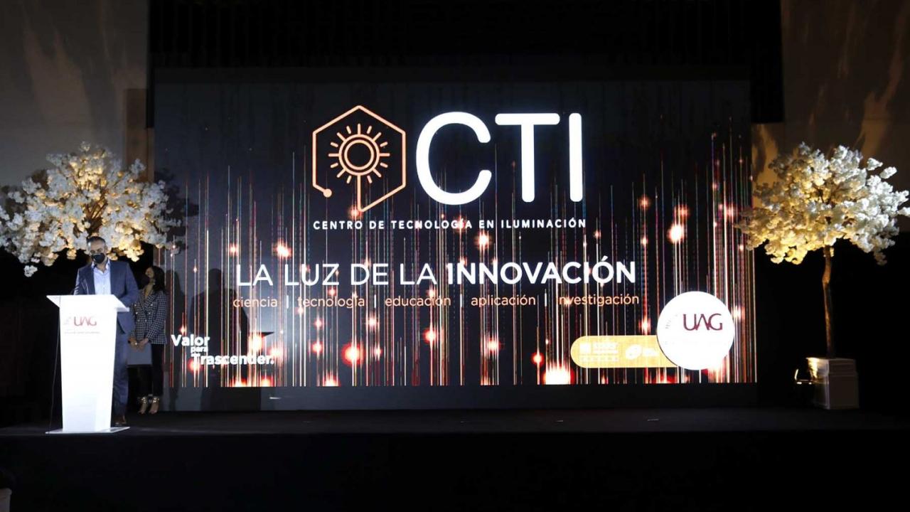 Photo of a stage with a backdrop that reads CTI Centro de Tecnologia en Iluminacion, LA LUZ DE INNOVACION