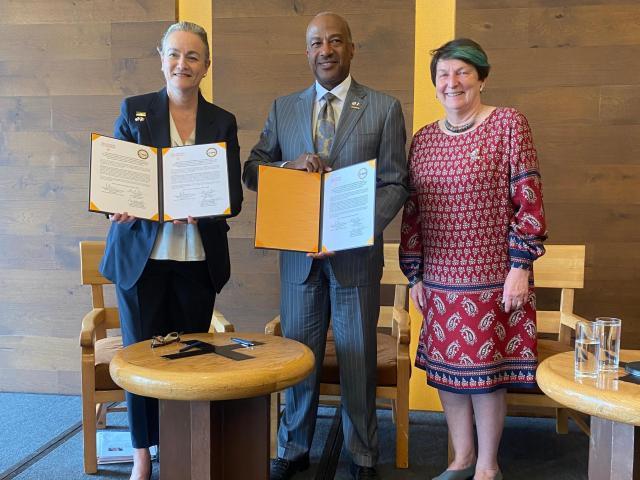 Chancellor May, Joanna Regulska, and an International Delegate gather around a newly signed agreement.