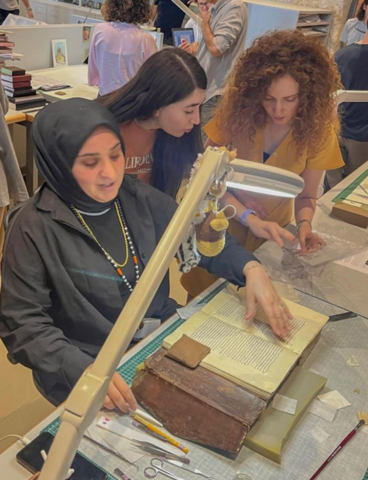 Elmira and a friend learn about Ottoman manuscript restoration from an expert.