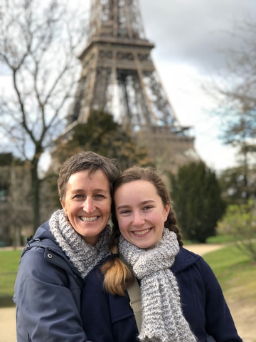 Karen and her daughter posing in front of the Eiffel Tower.
