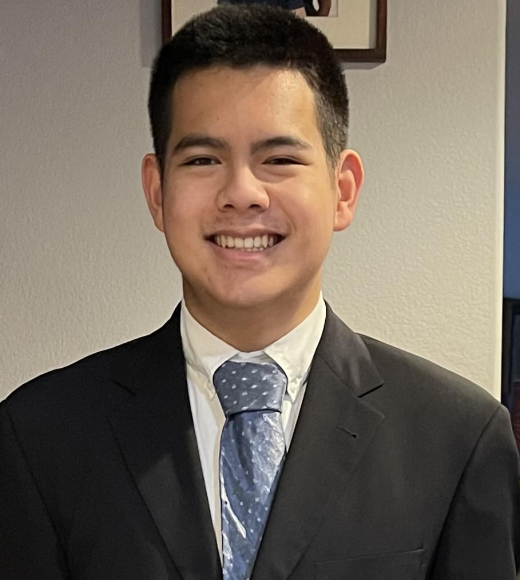 Aidan Chiang smiles in a suit and tie for a headshot.