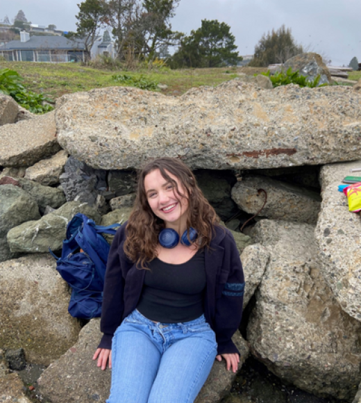 Monet Lahn sitting on rocks and smiling.