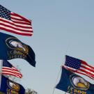 Flags representing the United States of America and the UC Davis Aggeis blow in the wind