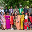25 Fellows in the 2022 UC Davis Mandela Washington Fellowship pose under a large tree wearing traditional cultural dress and business wear.