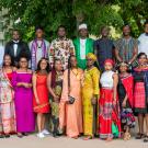 25 Fellows in the 2022 UC Davis Mandela Washington Fellowship pose under a large tree wearing traditional cultural dress and business wear.