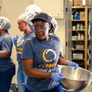Volunteers work in a kitchen preparing a meal