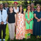 Twelve Humphrey Fellows stand together in two rows on the grass of a lawn on the UC Davis campus in the sunlight. They wear a combination of culturally traditional and business dress. 