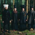 4 people stand together in the forest.