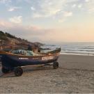Two fishing boats sit on the sand of a Brazilian beach.