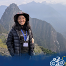 Jannet Torres Espinoza smiles at the camera with the mountains of Cusco, Peru in the background and a Global Aggies graphic overlay at the bottom