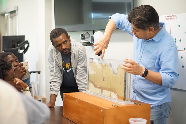man putting water in a box as people watch