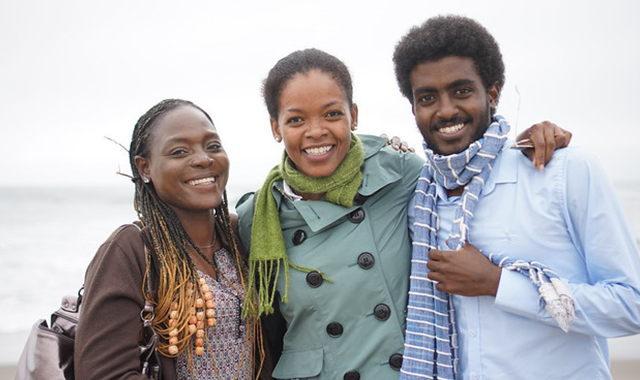 two women and a man in front of the golden gate bridge