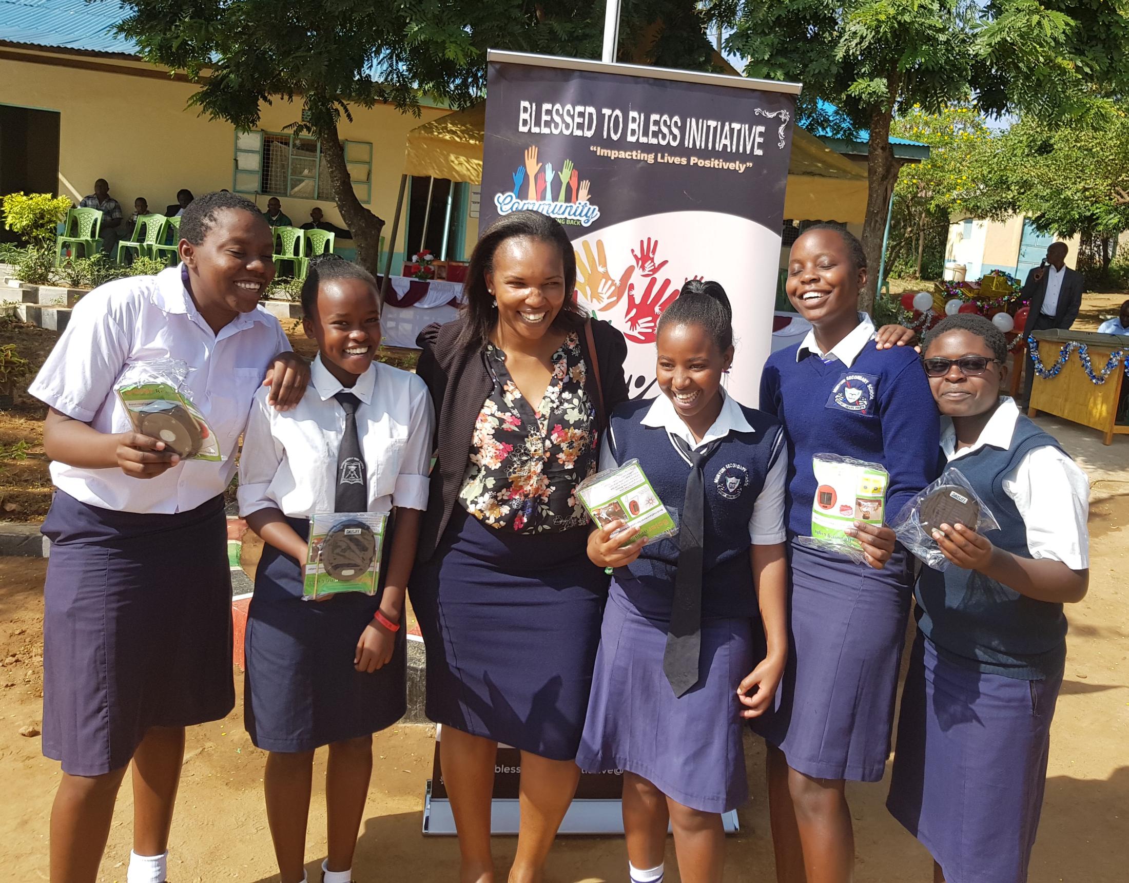 group of girls standing in front of a school in kenya